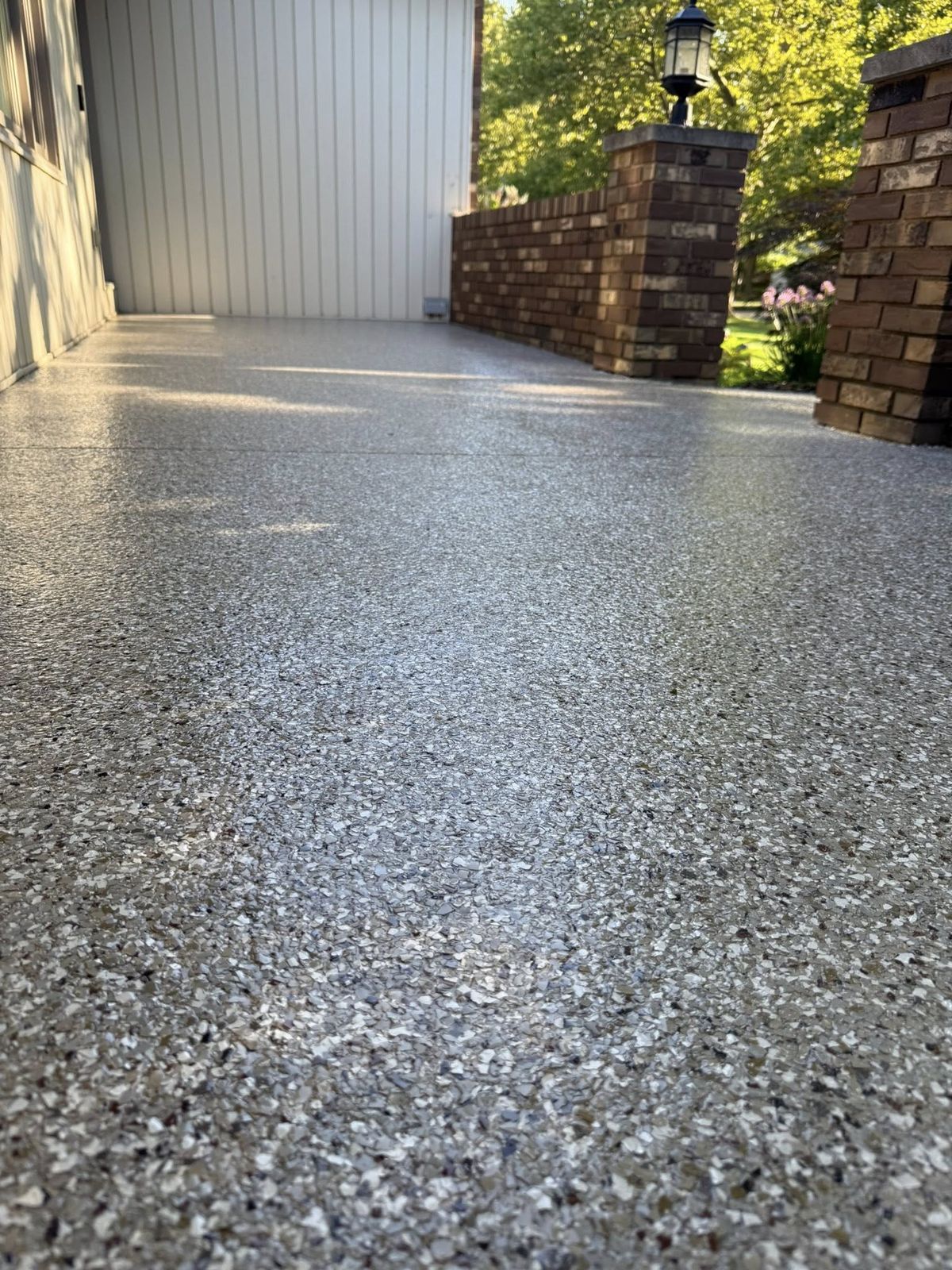 Flake coating on an outdoor entry walk between brick pillars