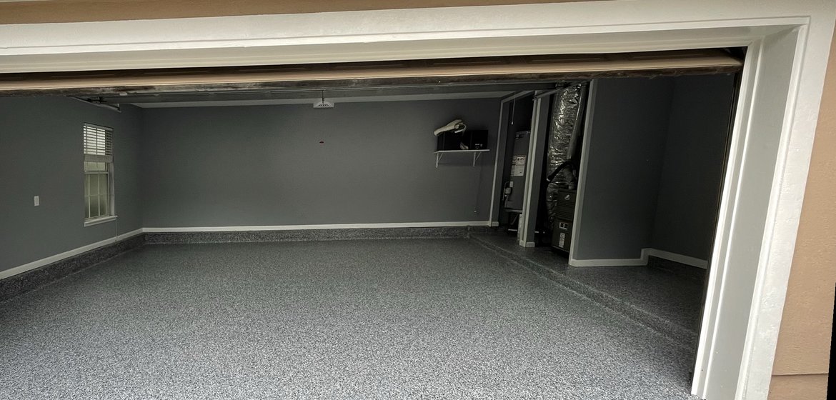 The same Palencia garage after diamond grinding and a grey flake polyaspartic coating, St. Augustine FL