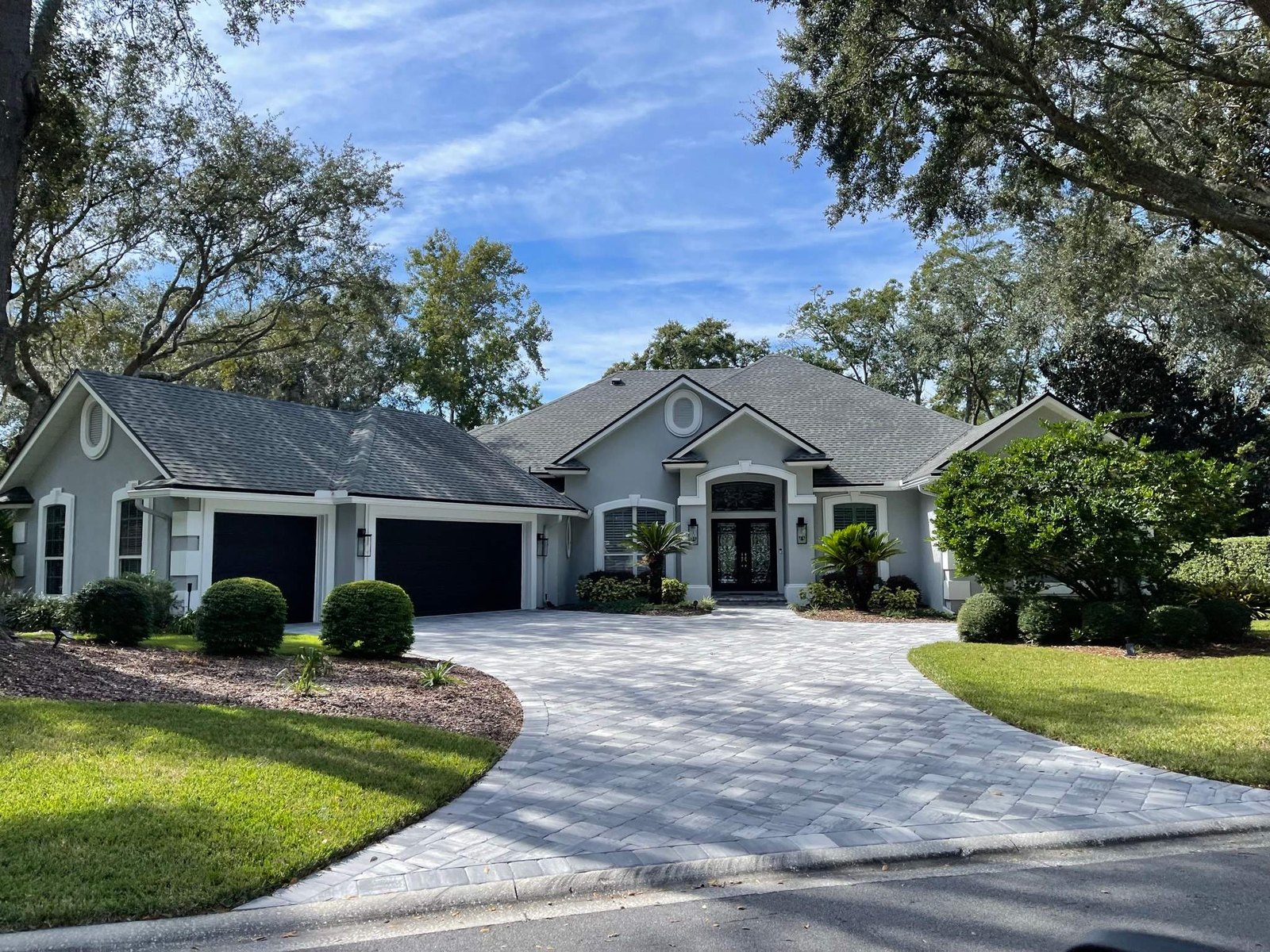 The same Queen's Harbor home after repainting, in soft slate with white trim and black garage doors, Jacksonville FL 32225