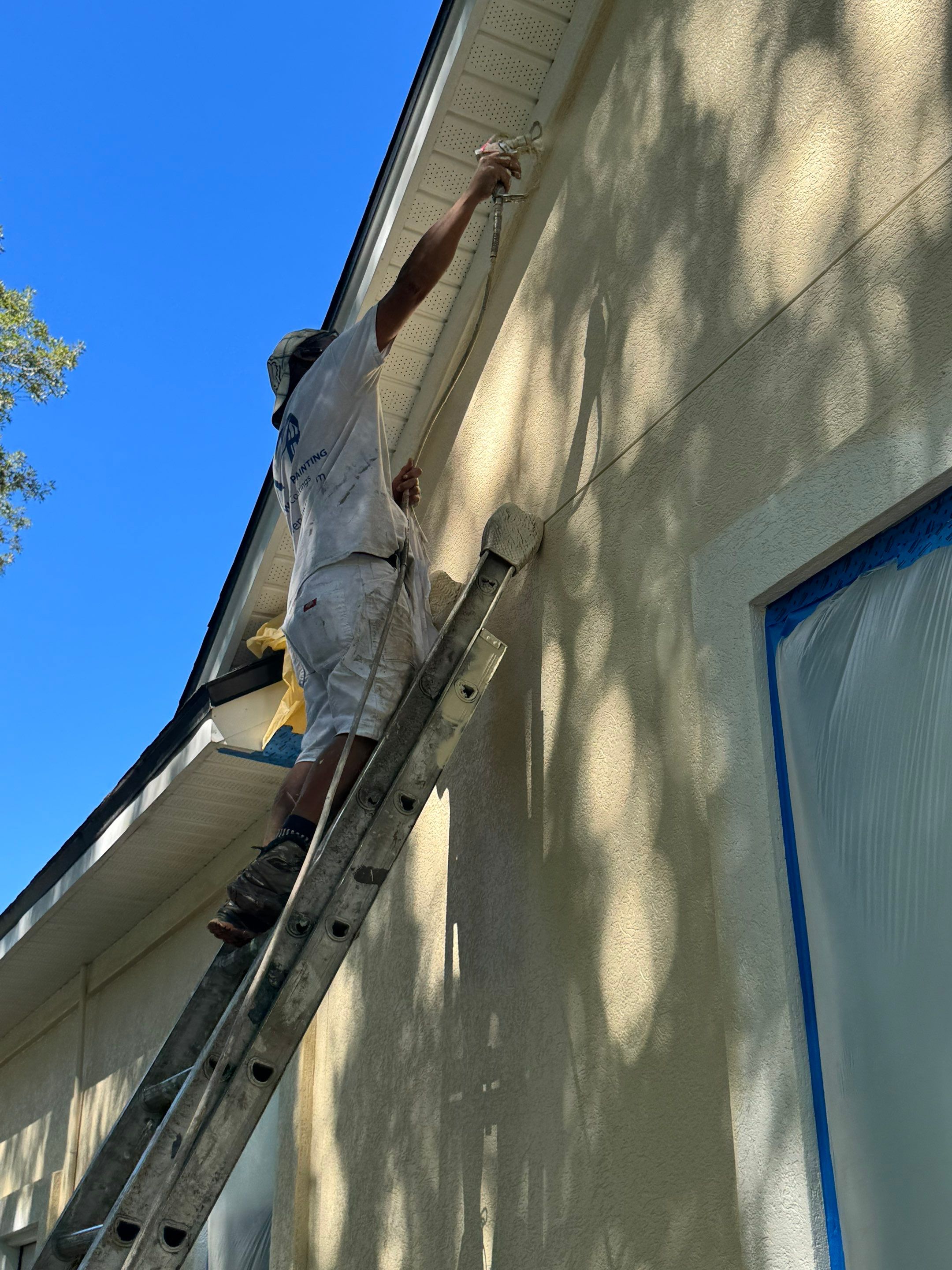 Crew applying exterior coatings to a synthetic stucco home in Queens Harbor