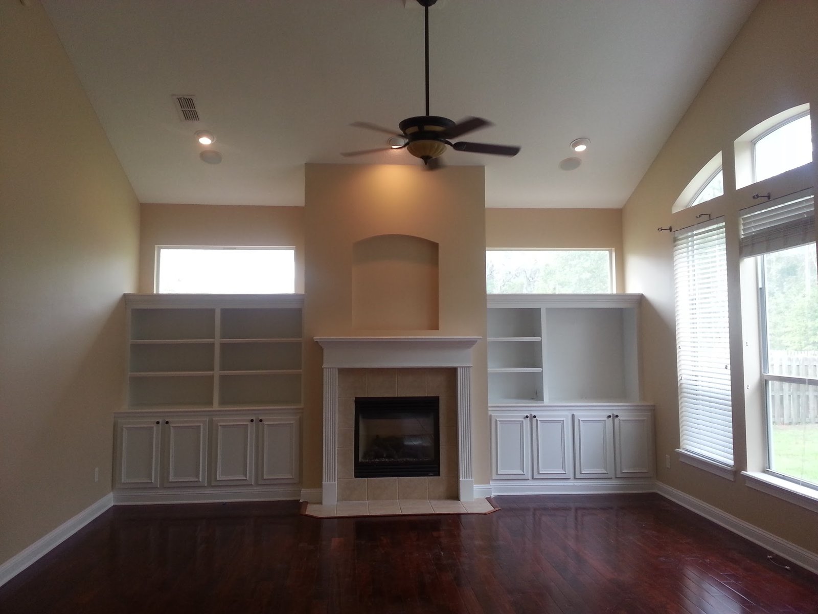 Living room with painted white built-in shelving and fireplace surround