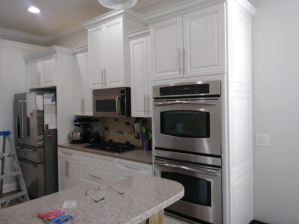 Kitchen cabinets prepared for painting with ladder in place