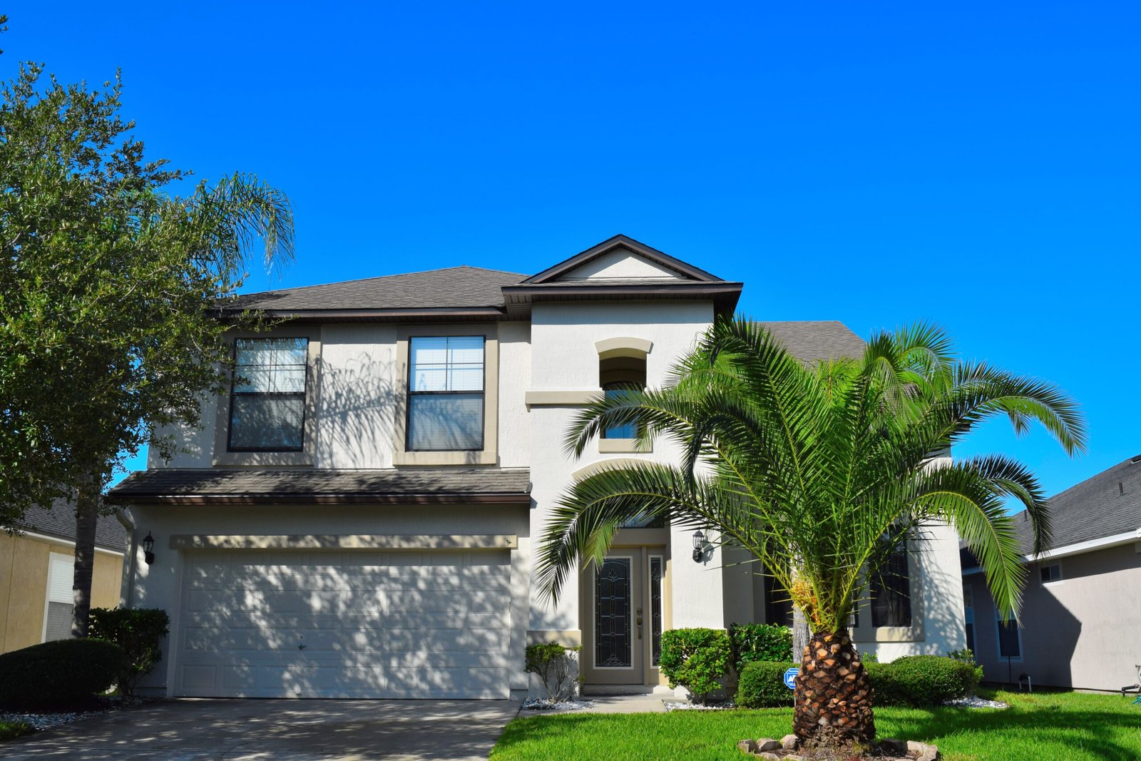 White two-storey stucco home after exterior repaint in OakLeaf Plantation, Jacksonville FL