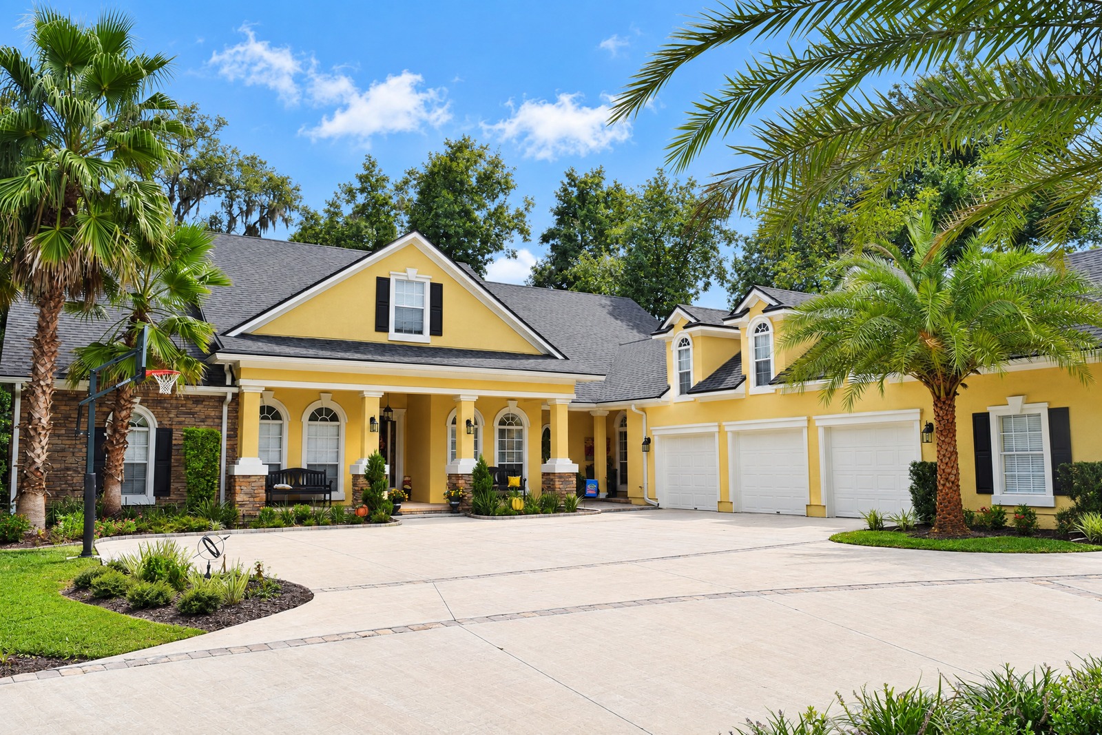 Yellow exterior with black shutters and three-car garage after repaint