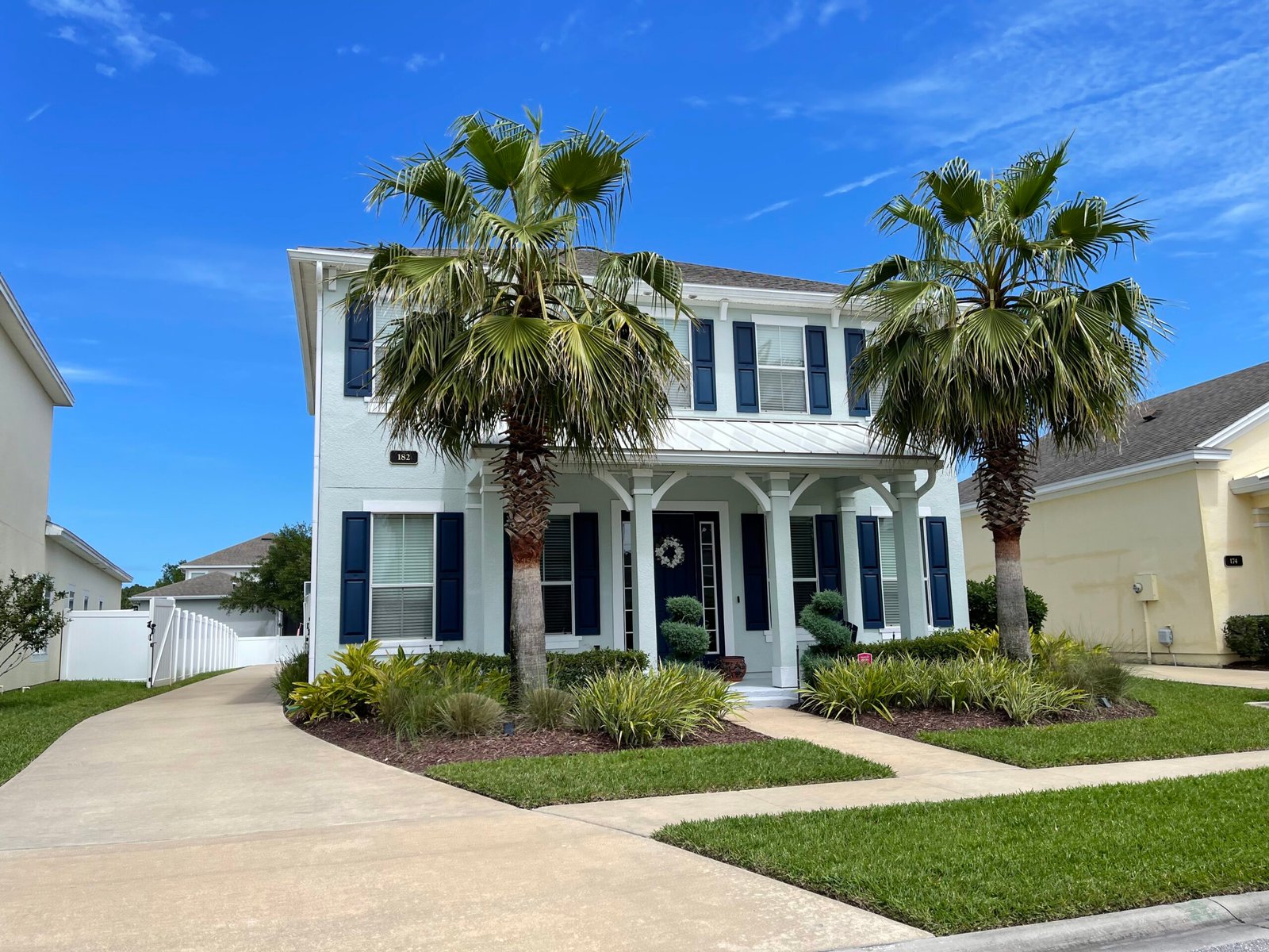 Mint green two-storey exterior with navy shutters after repaint