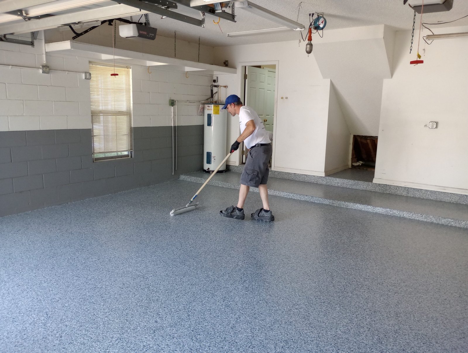 Painter rolling a garage floor coating