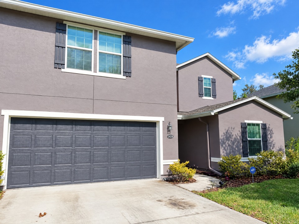 Mandarin stucco home after exterior repairs, caulking, priming and painting